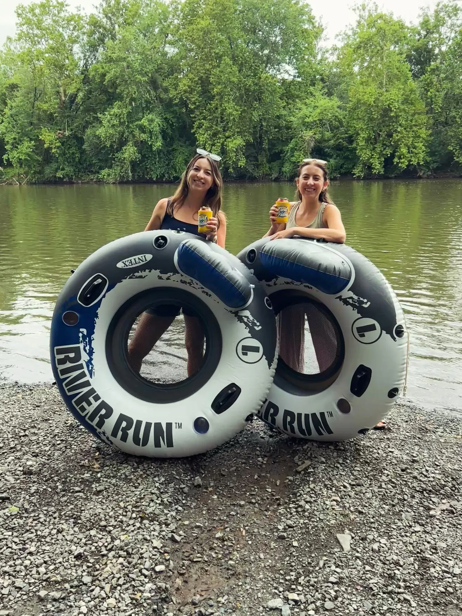 Two friends with tubes by the creek