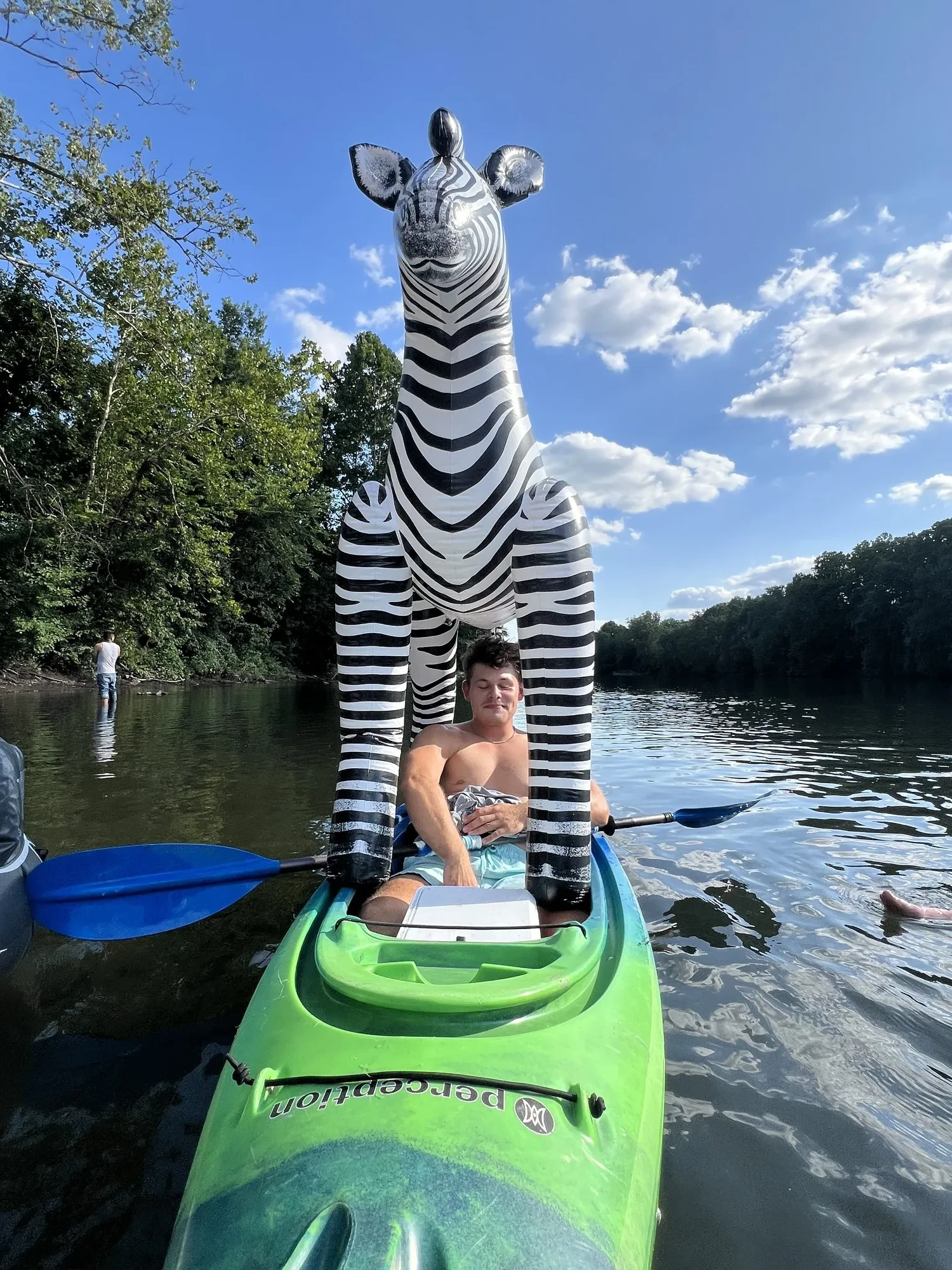 Person on zebra inflatable near kayak